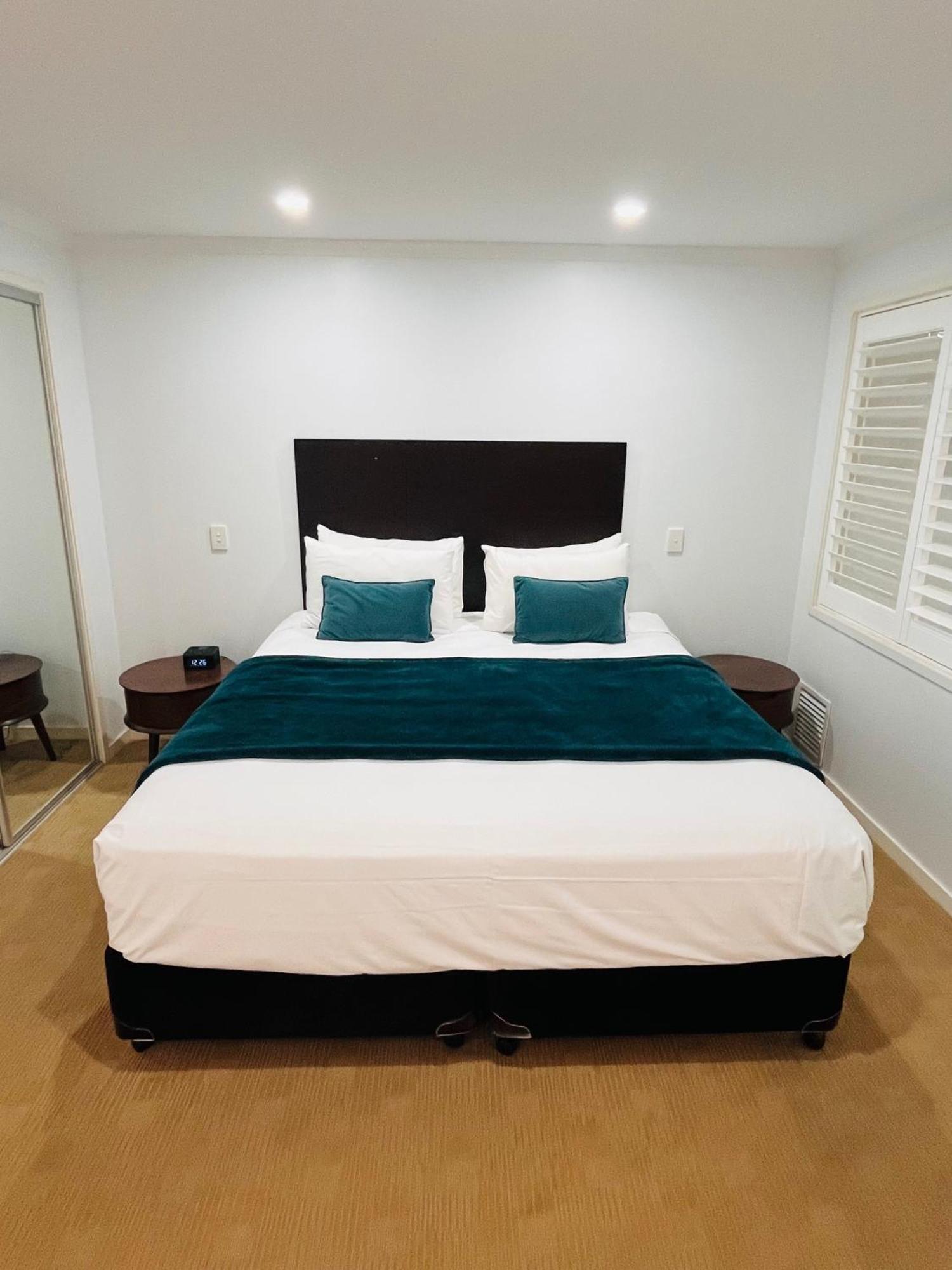 At Marina Shores Airlie Beach Exterior photo A bed with a bed runner